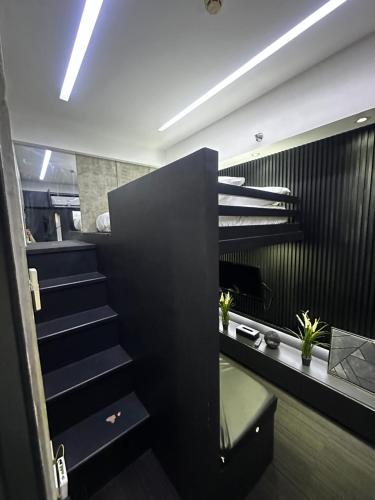 a staircase in a room with a black wall at Cloud & Rey condo rentals in Roxas City
