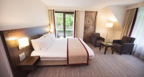 a hotel room with a bed and a balcony at Bilderberg Hotel De Bovenste Molen in Venlo