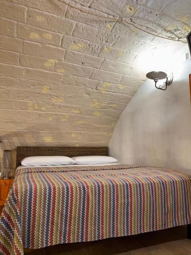 a bed in a room with a brick wall at More Apartments il castello in Bari
