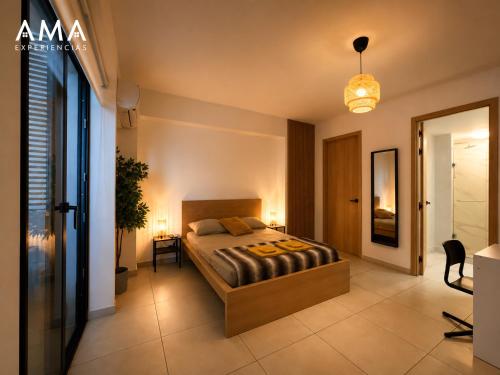 a bedroom with a bed and a desk and a lamp at Acogedor Apartamento Céntrico in Santo Domingo