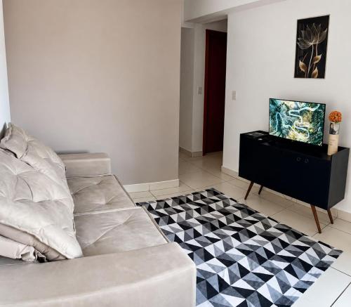 a living room with a couch and a checkered floor at Apartamento 02 QUARTOS, confortável no coração da Pampulha in Belo Horizonte