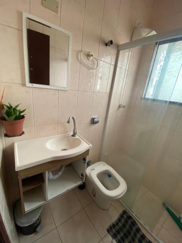 a bathroom with a toilet and a sink and a shower at Pousada Encanto De Itanhaém in Itanhaém