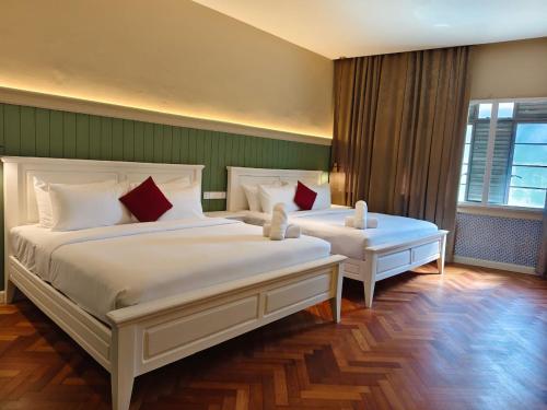 a bedroom with two beds and a window at The Chambers Georgetown in George Town