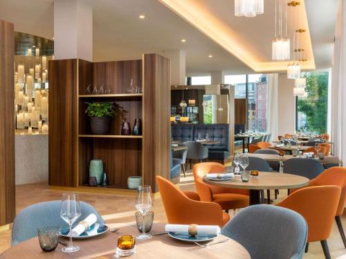 a dining room with tables and chairs and a restaurant at Mövenpick Hotel Basel in Basel