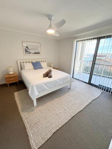 a bedroom with a bed with a teddy bear on it at Jubilee Apartment 06 in South West Rocks