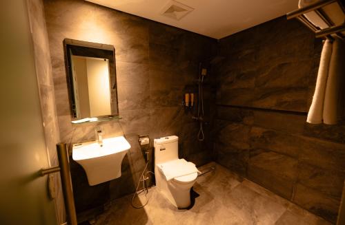 a bathroom with a toilet and a sink at Vibe Hotel Alabang in Manila