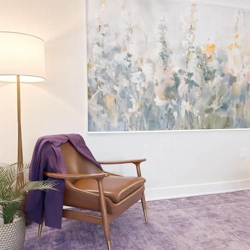 a chair in a room with a painting on the wall at 1500 Sq ft Space 2 Bed 2 Bath Large Kitchen in Conshohocken