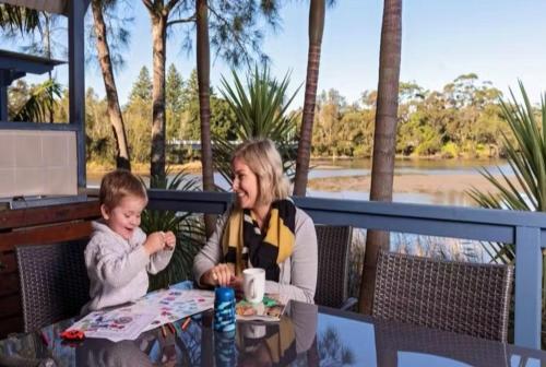 a woman and a child sitting at a table at Discovery Parks - Gerroa in Gerroa
