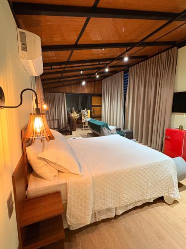 a bedroom with a large white bed in a room at Villa Iñaru hospedaria in Aquidauana