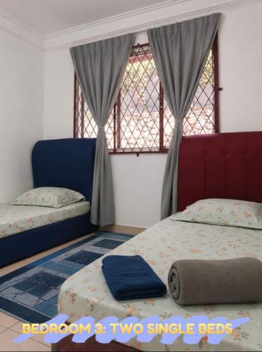a bedroom with two single beds and a window at D'Rembulan Homestay in Ranau