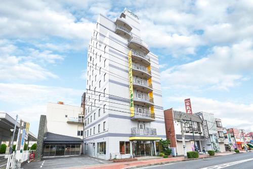 a tall white building on a city street at Hotel Select Inn Isehara in Isehara