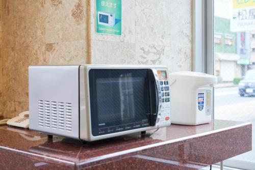 a microwave sitting on top of a counter at Hotel Select Inn Isehara in Isehara