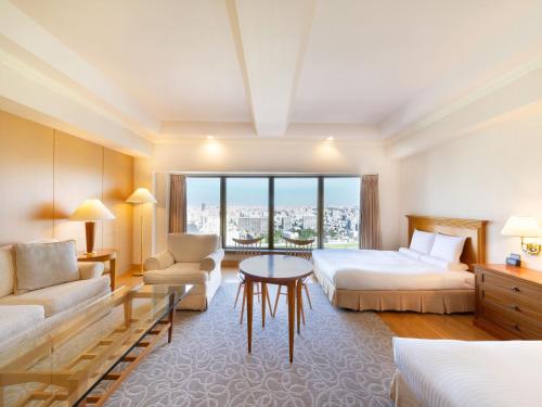 a hotel room with two beds and a table at HOTEL MYSTAYS PREMIER Sapporo Park in Sapporo