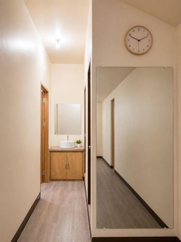 a hallway with a clock on the wall and a sink at Bayay Isla Inn in General Luna