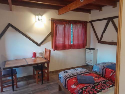 a bedroom with a desk and a bed and a table at Mi Refugio APART in El Chalten