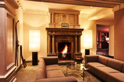 a living room with a fireplace and a couch at Steigenberger Grandhotel Belvedere in Davos