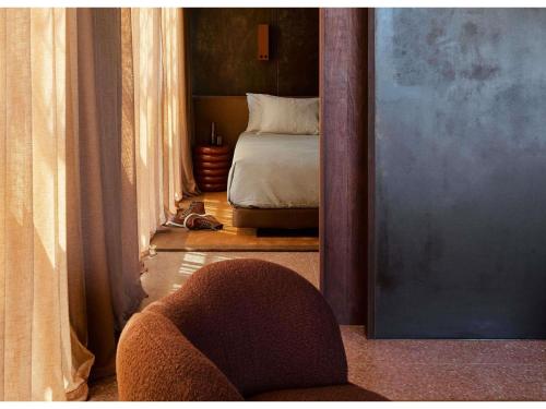 a bedroom with a bed and a chair in a room at Hyde Melbourne Place in Melbourne