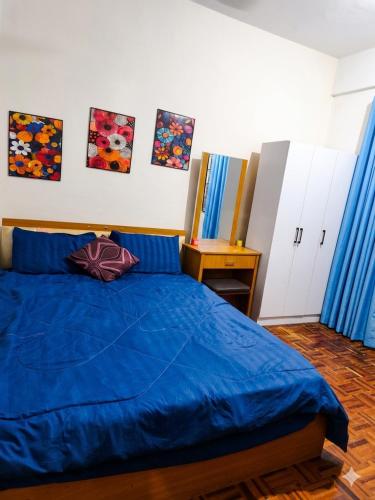 a bedroom with a blue bed with blue sheets at MonoStay Samarahan in Kota Samarahan