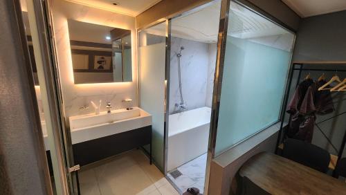 a bathroom with a shower and a sink and a mirror at Sixty Hotel in Seoul