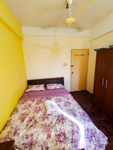 a bedroom with a large bed with a purple comforter at MonoStay Samarahan in Kota Samarahan
