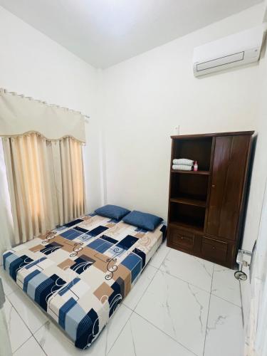 a bedroom with a bed and a cabinet at Jhuna Komodo Homestay in Komodo