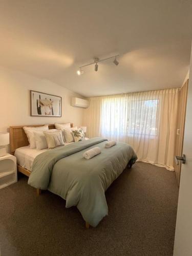 a bedroom with a large bed with two towels on it at Iluka in Yeppoon