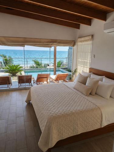 a bedroom with a bed and a view of the ocean at La Casa de David in Zorritos