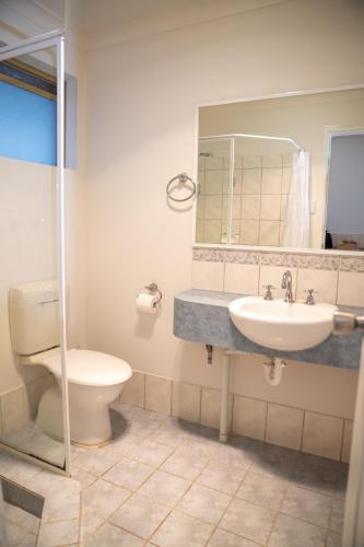 a bathroom with a sink and a toilet and a mirror at Rec Toodyay Hotel in Toodyay