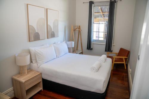 a bedroom with a bed with two towels on it at Rec Toodyay Hotel in Toodyay