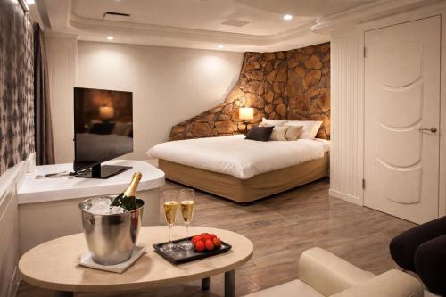 a hotel room with a bed and a table with wine glasses at Hotel Piatt Nagoya in Nagoya
