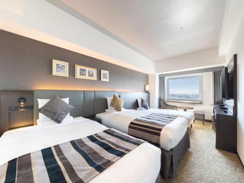 a hotel room with two beds and a television at HOTEL MYSTAYS PREMIER Sapporo Park in Sapporo
