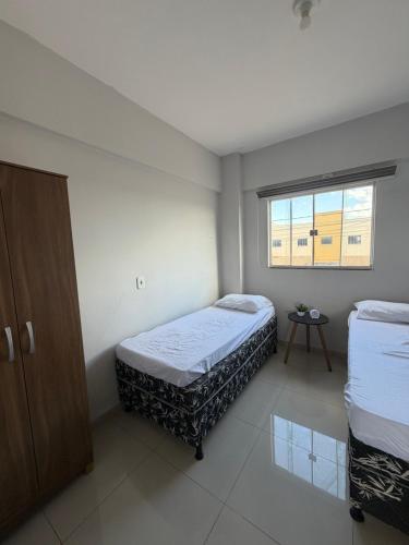 a bedroom with two beds and a window at Apartamento completo in Nova Mutum