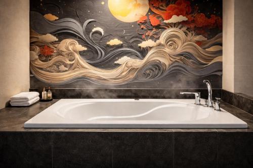 a bath tub in a bathroom with a mural at Hotel Piatt Nagoya in Nagoya