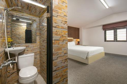 a bedroom with a bed and a bathroom with a sink at Hanoi Kingly Hotel in Hanoi