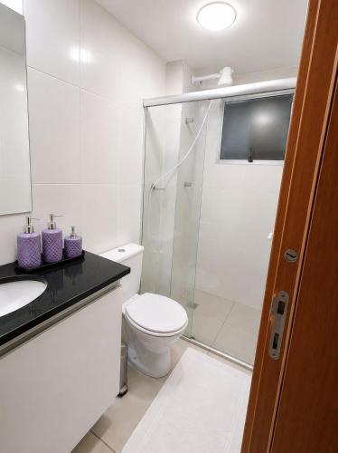a white bathroom with a toilet and a shower at Apartamento 02 QUARTOS, confortável no coração da Pampulha in Belo Horizonte