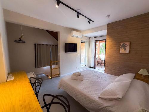 a bedroom with a large white bed in a room at Villa'l Mare Hotel in Maresias