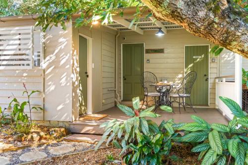 a patio with a table and chairs on it at Treehaven House & Cottage - Maleny Retreat in Maleny