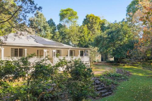a house with a fence and a yard at Treehaven House & Cottage - Maleny Retreat in Maleny