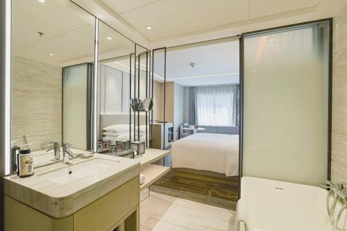 a bathroom with a sink and a bed in a room at Renaissance Shenzhen Luohu Hotel in Shenzhen