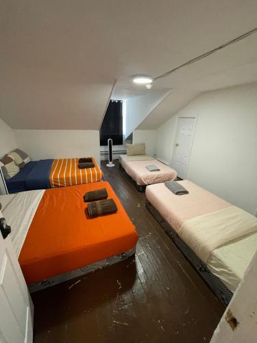 a room with two beds and an orange mattress at City Centre Suite, Steps to UofT, TMU, Yonge-Dundas Square in Toronto