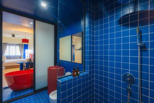 a blue tiled bathroom with a red tub and a red toilet at Lot 78 in Malacca