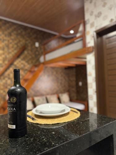 a bottle of wine sitting on a counter with a plate at Condomínio Feitosa Barros I in Maceió