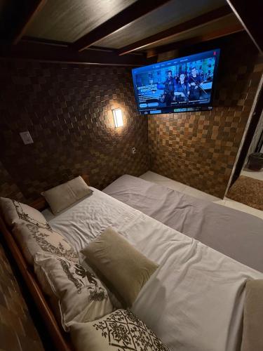 a bedroom with two beds and a flat screen tv at Condomínio Feitosa Barros I in Maceió