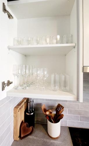 a shelf with wine glasses and a vase on it at Poolside Retreat 250m From Beach Resort Facilities in Mandurah