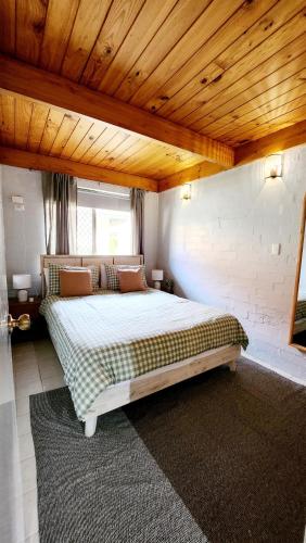a bedroom with a large bed with a wooden ceiling at Poolside Retreat 250m From Beach Resort Facilities in Mandurah
