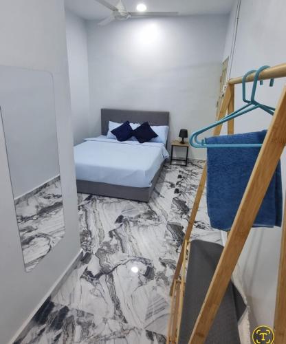 a bedroom with a bed with a marble floor at homestay chendorini cherating in Kampong Chendar