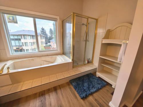 a bathroom with a tub and a window at Metta Stays Edgemont in Calgary