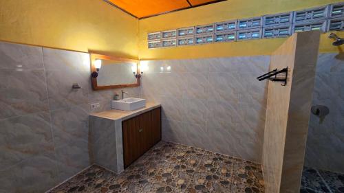 a bathroom with a sink and a mirror at Tangkoko Sanctuary Villa in Bitung