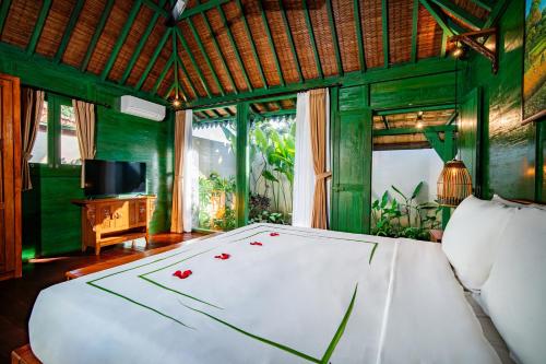 a bedroom with a large bed with red flowers on it at Juwel Villa Ubud in Ubud