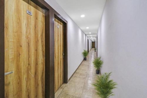 a corridor with potted plants in an office building at Hotel O Fox Guest House in Greater Noida